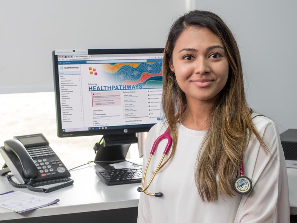 Doctor looking at camera with Murray HealthPathways on her computer screen in the background